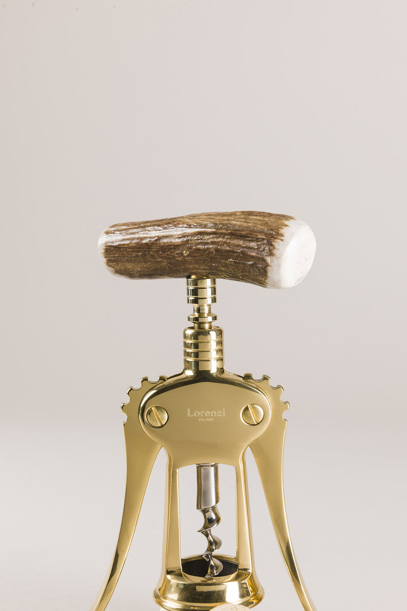 old hand made solid brass corkscrew on a natural wood background